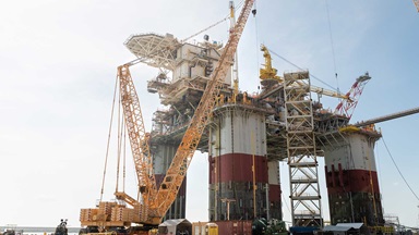 an oil rig on the water with lots of construction cranes around it