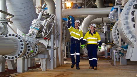 Two workers walking through the Offshore Wheatstone LNG Facilities.